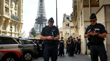 Petugas polisi berkumpul di sebuah jalan dekat Menara Eiffel jelang malam upacara pembukaan Paralimpiade Paris 2024, Selasa, 27 Agustus 2024 di Paris. (AP Photo/Thomas Padilla)