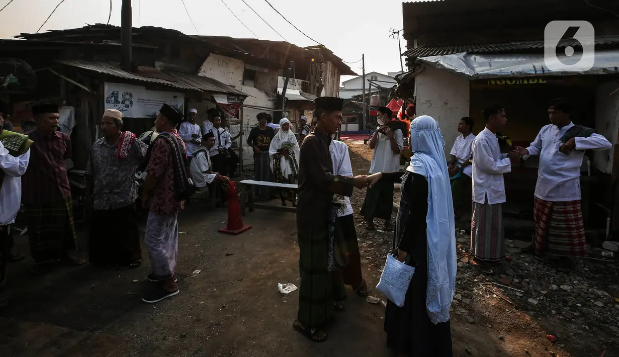 Warga bersalaman saat merayakan Idul Fitri di Pancoran Buntu II, Jakarta Selatan. Kamis (13/5/2021). Mayoritas umat Muslim di Indonesia melaksanakan Sholat Id sesuai dengan ketetapan pemerintah pada Rabu (13/5/2021). (Liputan6.com/Johan Tallo)