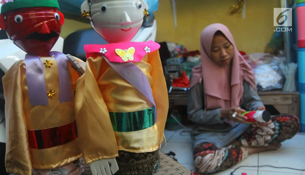Perajin menyelesaikan pembuatan miniatur ondel-ondel di rumah produksi Kramat Jati, Jakarta, Senin (23/6/2019). Perajin bisa mengumpulkan omzet mencapai Rp 5 juta hingga Rp 8 juta per bulan. (merdeka.com/Arie Basuki)