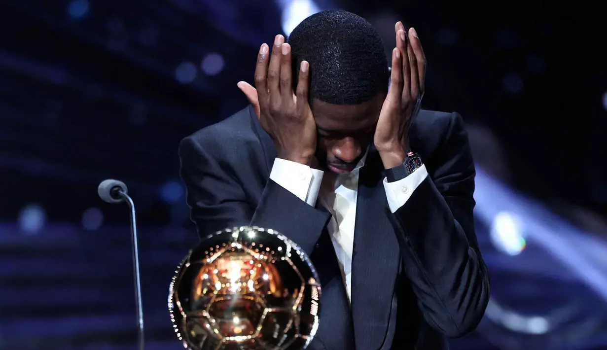 Penyerang Prancis Paris Saint-Germain, Ousmane Dembele bereaksi setelah menerima penghargaan Ballon d'Or selama upacara penghargaan Ballon d'Or France Football 2025 di Teater du Chatelet, Paris pada 22 September 2025 waktu setempat atau Selasa (23/9/2025) dini hari WIB. (Franck FIFE/AFP)