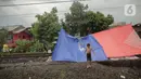 Tenda pengungsi banjir yang didirikan di jalur rel kereta commuterline Tangerang-Duri di Kembangan Baru, Jakarta, Jumat (3/1/2020). Jalur rel yang nonaktif sementara karena banjir dimanfaatkan warga untuk mendirikan tenda darurat karena rumah mereka masih terendam. (Liputan6.com/Faizal Fanani)