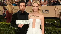 Aktor Simon Helberg dan istri, Jocelyn Towne menarik perhatian di karpet merah ajang SAG Awards di Los Angeles, Minggu (29/1). Istri bintang 'The Big Bang Theory' tersebut menuliskan kalimat 'Let Them In' di atas dadanya. (Jordan Strauss/Invision/AP)