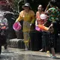 Warga menghujani pengendara sepeda motor dengan air saat merayakan Festival Songkran atau Tahun Baru Thailand di Narathiwat, Thailand, 13 April 2019. Festival ini rutin diselenggarakan setiap tanggal 13-15 April setiap tahunnya. (Madaree TOHLALA/AFP)