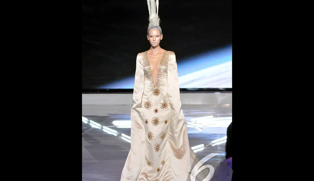 Gaun putih berkerah `V` hingga ke perut dengan hiasan emas menampilkan sosok putri nan dingin seperti es  dalam I Fashion Festival 2014, Jakarta, Senin (15/12/2014). (Liputan6.com/Panji Diksana)