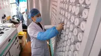 Petugas medis mengambil obat-obatan di sebuah rumah sakit keliling di Distrik Chang'an, Provinsi Hebei, 12 Maret 2020. Sebuah rumah sakit pengobatan tradisional China keliling menyediakan layanan kesehatan bagi penduduk setempat di tengah perang melawan virus corona COVID-19. (Xinhua/Liang Zidong)