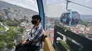 Penumpang melakukan perjalanan dengan sistem kereta gantung yang dijuluki Cablebus setelah peresmiannya di pinggiran Mexico City, Meksiko, 12 Juli 2021. Sistem kereta gantung ini memudahkan penumpang untuk melakukan perjalanan dari Cuautepec menuju pusat kota. (PEDRO PARDO/AFP)