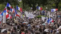 Ribuan pengunjuk rasa berkumpul di Place Trocadero dekat Menara Eiffel menghadiri demonstrasi di Paris, Prancis, Sabtu 24 Juli 2021, menentang izin COVID-19 yang memberikan kemudahan akses yang lebih besar kepada individu yang divaksinasi ke tempat-tempat. (AP Photo/Rafael Yaghobzadeh)