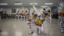 Sejumlah anggota cheerleaders Cheer Mommy membentuk formasi saat berlatih di ruang latihan di Samcheok, Korsel (3/3). Walaupun dengan nafas yang terengah-engah dan berkeringat, mereka tetap bersemangat melakukan bermacam gerakan. (AFP/Ed Jones)
