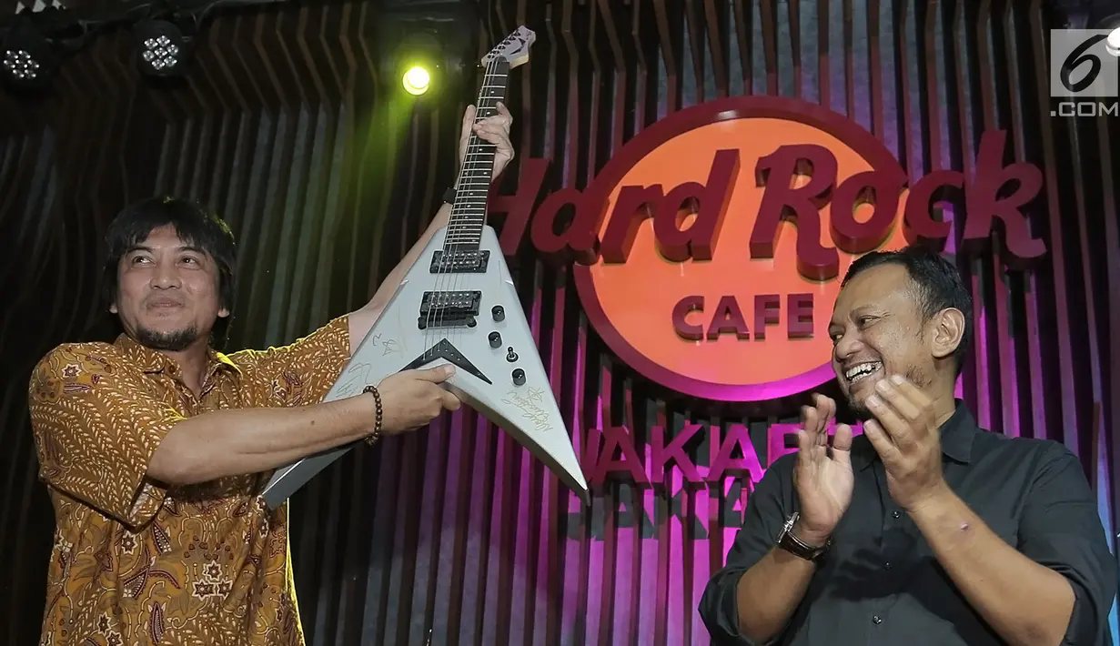 Pemenang lelang diwakili Eddy Gun (kiri) menerima gitar milik band Megadeth yang dilelang dalam acara di Jakarta, Jumat (30/11). Gitar yang dilelang untuk membantu korban gempa di Palu dan Donggala itu terjual seharga Rp150 juta. (New Fimela/Bambang Eros)