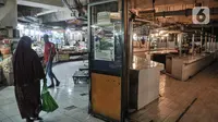 Warga melintasi kios daging sapi yang sedang tutup di Pasar Tebet, Jakarta, Selasa (1/3/2022). Pedagang daging sapi di Jakarta serentak melakukan aksi mogok berjualan hingga Jumat (4/3) sebagai bentuk protes atas kenaikan harga daging yang tembus hingga Rp140.000 per kg (merdeka.com/Iqbal S Nugroho)