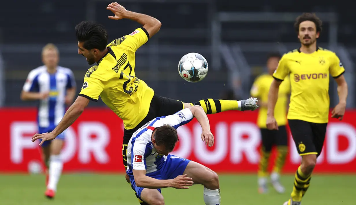 Pemain Borussia Dortmund, Emre Can, berebut bola dengan pemain Hertha Berlin, Vladimir Darida, pada laga Bundesliga di Stadion di Signal Iduna Park, Sabtu (6/6/2020). Borussia Dortmund menang 1-0 atas Hertha Berlin. (AP/Lars Baron)