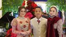 Celine Evangelista tampil mengenakan ball gown warna pink lengan panjang balon. Dress pub memiliki motif bunga mawar merah di bagian depan. Ia pun mengenakan kalung choker layering mutiara. [@aanstory]
