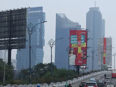 Sejumlah kendaraan melintas di sisi papan reklame di sekitar Jalan HR Rasuna Said, Jakarta, Sabtu (20/12). Pemerintah Provinsi DKI Jakarta akan menurunkan sebanyak 60 papan reklame yang dianggap melakukan pelanggaran. (Liputan6.com/Helmi Fithriansyah)