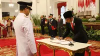 Presiden Joko Widodo menandatangangi berita acara saat pelantikan Anies Baswedan sebagai Gubernur DKI Jakarta periode 2017-2022 di Istana Negara, Jakarta, Senin (16/10). (Liputan6.com/Angga Yuniar)