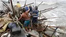 Keluarga Taroyo yang tinggal di sepanjang pantai Teluk Manila mencari barang yang bisa diselamatkan setelah rumah mereka rusak akibat Topan Koppu, Minggu (18/10). Topan Koppu melanda Filipina timur laut dan merusak rumah-rumah. (REUTERS/Romeo Ranoco)