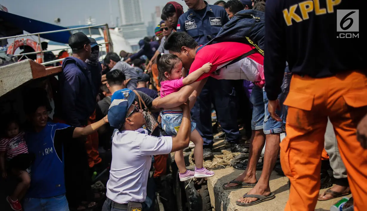 Petugas membantu seorang anak menaiki kapal menuju Kepulauan Seribu di Pelabuhan Kali Adem, Jakarta, Sabtu (8/6/2019). Beberapa pulau di wilayah Kepulauan Seribu menjadi pilihan favorit banyak warga Ibu Kota dan sekitarnya yang memanfaatkan momen liburan Lebaran. (Liputan6.com/Faizal Fanani)
