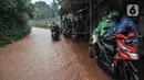 Aliran genangan lumpur yang berasal dari jalan masuk perumahan Depok Jaya Agung, Sawangan, Depok, Minggu (7/11/2021). Hujan deras yang mengguyur Depok dan sekitarnya menyebabkan Jalan Raya Sawangan  digenangi banjir lumpur dan membahyakan keselamatan pengendara. (merdeka.com/Iqbal S Nugroho)