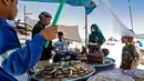 Warga Suriah yang terlantar menunggu pesanan permen mereka selama bulan suci Ramadan di kamp Washukanni untuk para pengungsi internal di provinsi Hasakeh di timur laut Suriah, (10/5/2020). (AFP/Delil Souleiman)