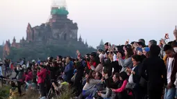 Wisatawan lokal dan asing mengunjungi kuil tua Myanmar sesaat sebelum matahari terbit di Bagan, distrik Nyaung U, Myanmar tengah (16/12). Banyak wisatawan menggunakan balon udara untuk menikmati pemandangan langit Bagan. (AP Photo/Aung Shine Oo)