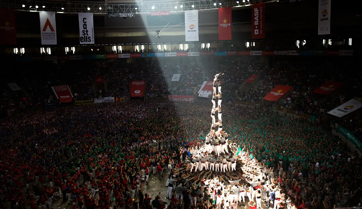Anggota "Castellers de Sants" membentuk menara manusia selama Kompetisi Tower Manusia di Tarragona, Spanyol, Minggu (7/10). Setiap tower manusia biasanya tingginya sekitar 6 sampai sepuluh tingkat. (AP/Emilio Morenatti)