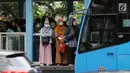 Warga menunggu bus Transjakarta di halte Bundaran Senayan, Jakarta, Jumat (14/7). Menurut Kepala Dinas LHK DKI Jakarta Isnawa Adji, kualitas udara yang buruk terjadi di hampir seluruh Jakarta terutama di pusat industri. (Liputan6.com/Helmi Fithriansyah)