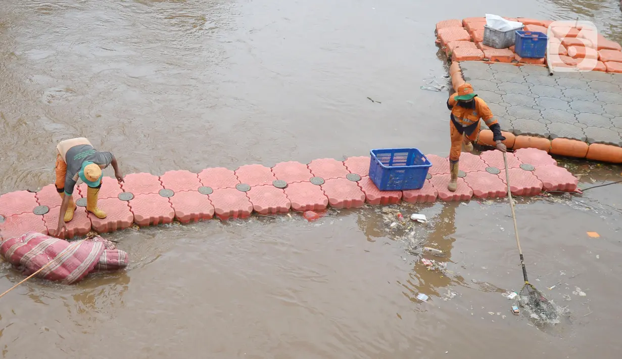 Pekerja Dinas Kebersihan mengangkat sampah kasur di Kali Pesanggrahan, Jakarta Selatan, Rabu (4/11/2020). Sampah-sampah yang terbawa arus air terjaring di penyaringan sampah yang dipasang untuk mengantisipasi penyumbatan pada musim penghujan bisa terjadi banjir. (merdeka.com/Dwi Narwoko)