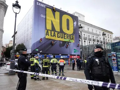 Petugas polisi membentuk perimeter saat aktivis Greenpeace membentangkan spanduk besar bertuliskan "Tidak untuk Perang" sebagai bentuk protes terhadap serangan Amerika Serikat (AS) dan Israel terhadap Iran, di Lapangan Puerta del Sol, Madrid, Spanyol, pada Selasa 10 Maret 2026. Aksi unjuk rasa merespons serangan militer Amerika Serikat dan Israel ke Iran marak terjadi secara global, termasuk di Kota Madrid, Spanyol. (Paul Hanna/AFP)