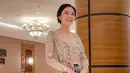 Tampil fresh, Wika Salim memadukan kebaya brokat warna krem, midi skirt batik berdetail slit, studded heels, serta handbag. (Instagram/wikasalim).