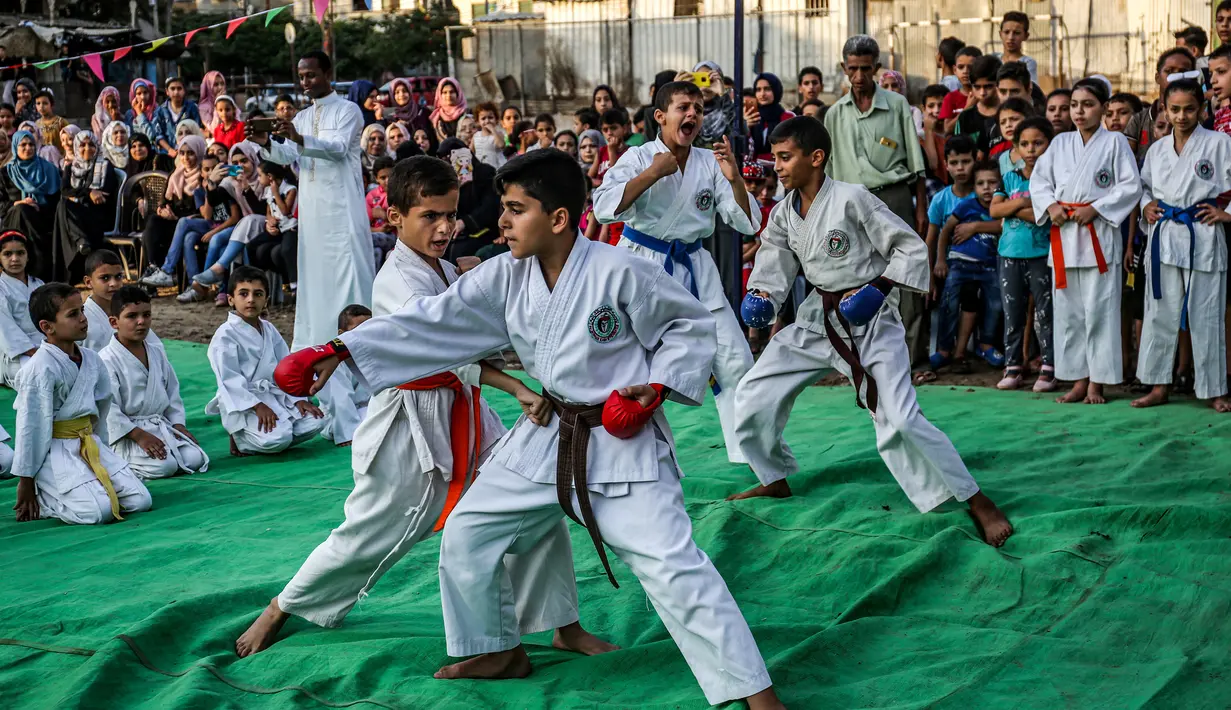 Anak-anak Palestina menunjukkan keterampilannya selama upacara promosi Karate di sebuah pusat olahraga di kamp Rafah untuk pengungsi Palestina di Jalur Gaza selatan (20/9/2019). (AFP Photo/Said Khatib)
