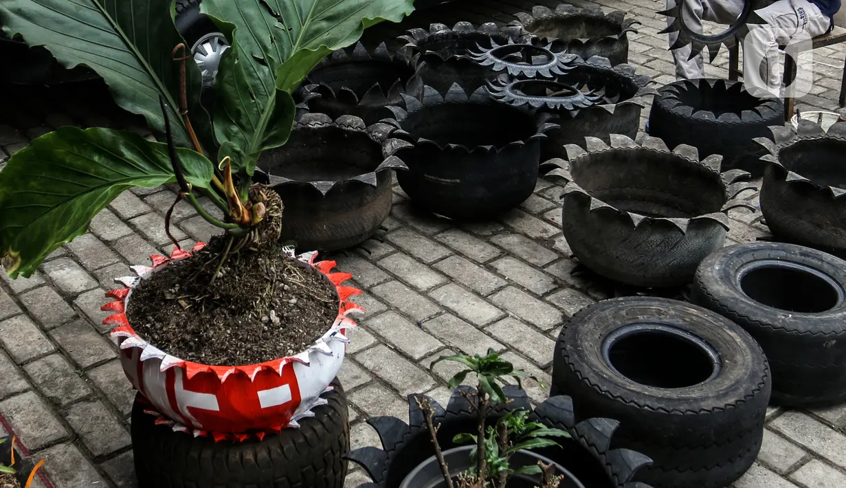 <p>Abdul Kholik (30) menyelesaikan pembuatan pot bunga dari ban bekas di Galeri Abdul Kholik, Tapos, Depok, Jumat (30/10/2020). Limbah ban bekas mobil Boogie Car atau mobil golf dimanfaatkan oleh Karang Taruna Kelurahan Cimpaeun sebagai bahan baku kerajinan pot bunga. (Liputan6.com/Johan Tallo)</p>