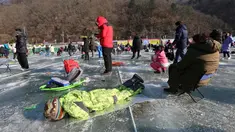 Peserta memancing ikan trout melalui lubang yang mereka buat di atas sungai beku di Hwacheon, Korea Selatan, Sabtu (5/1). Kontes ini merupakan bagian dari festival es tahunan yang menarik lebih dari satu juta pengunjung setiap tahun. (AP/Ahn Young-joon)