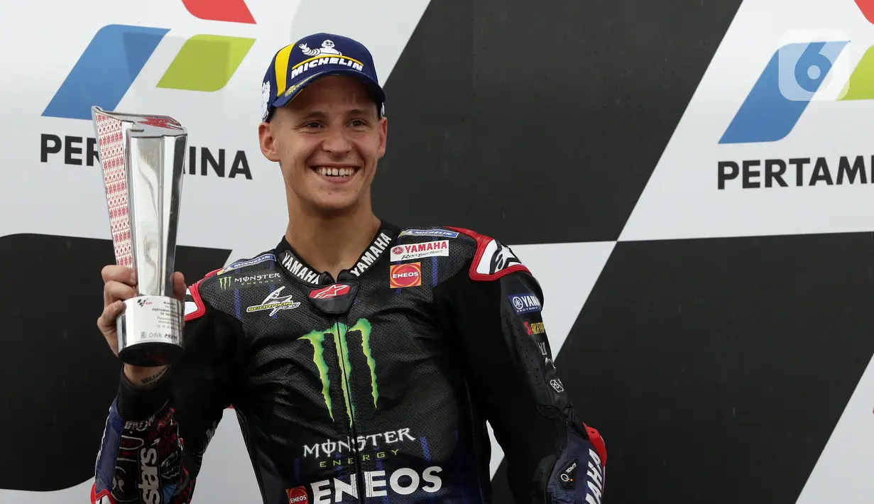 Pembalap Monster Energy Yamaha MotoGP, Fabio Quartararo mengangkat piala posisi kedua Pertamina Mandalika International Street Sirkuit, NTB, Minggu (20/3/2022). Pembalap Red Bull KTM Factory Racing, Miguel Oliveira menempati posisi pertama MotoGP Mandalika 2022. (Liputan6.com/Helmi Fithriansyah)