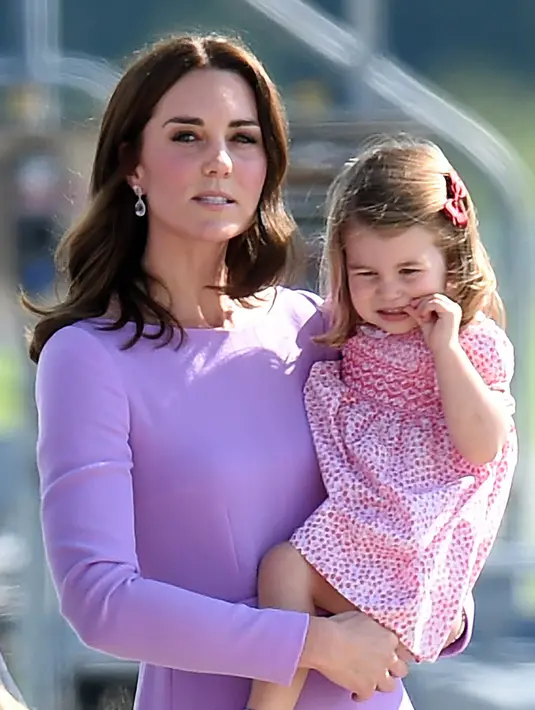 Putri Charlotte menangis dalam gendongan sang ibu, Kate Middleton dalam kunjungan mereka ke Pabrik Airbus di Hamburg, Jerman, 21 Juli 2017. Putri Charlotte mendadak merajuk dan enggan naik helikopter di pabrik pesawat terbang itu. (AP Photo)