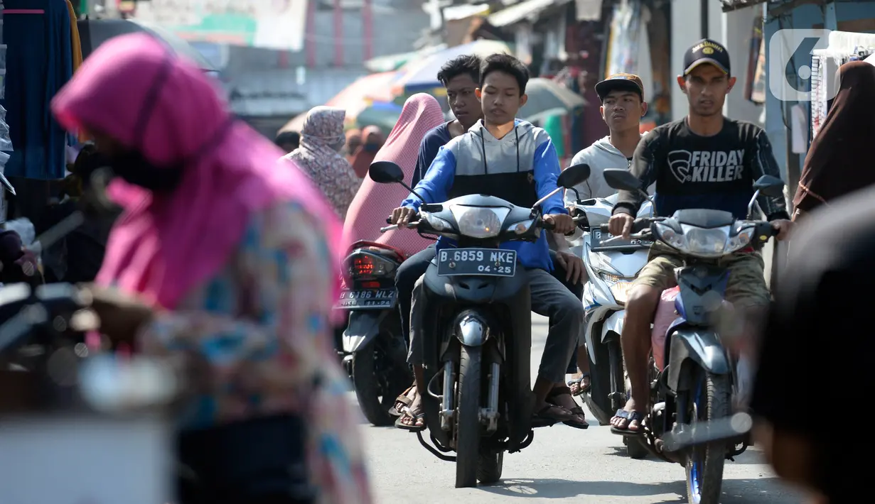 Pengendara motor tidak mengenakan masker masuk ke Pasar Bukit di Tangerang Selatan, Banten, Rabu (22/7/2020). Warga masih tidak peduli kesehatan dirinya sendiri dan orang lain, tentang bahayanya penyeberan virus corona (COVID-19) yang terus meningkat di Indonesia. (merdeka.com/Dwi Narwoko)