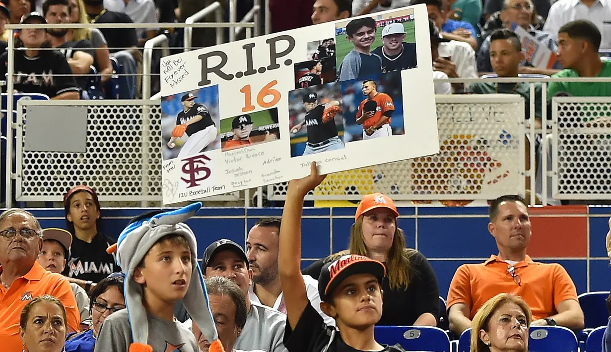 Penggemar memperlihatkan gambar Jose Fernandez saat Tim Bisbol Miami Marlins melawan New York Mets di Marlins Park, Senin (26/9). (Reuters/ Jasen Vinlove/ USA TODAY Sport)