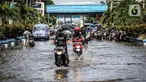 Kendaraan bermotor melintasi jalan yang tergenang air rob (banjir pasang air laut) di Kawasan Pasar Ikan Muara Baru, Jakarta, Kamis (4/6/2020). Banjir rob di Pelabuhan Muara Baru tersebut terjadi akibat cuaca ekstrem serta pasangnya air laut. (Liputan6.com/Faizal Fanani)