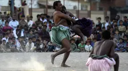 Pegulat bertarung selama turnamen gulat tradisional Sindhi Malakhra di kota pelabuhan Karachi, Pakistan pada Minggu (13/12/2020). Gulat kuno yang dimulai sejak 5.000 tahun lalu ini salah satu olahraga favorit di kalangan pria. (Photo by Asif HASSAN / AFP)