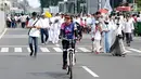 Seorang warga bersepeda di antara peserta Reuni 212 saat Car Free Day (CFD) di kawasan Jakarta, Minggu (2/12). Warga tetap memadati area Car Free Day  dari Bundaran HI-Sudirman meskipun ada aksi Reuni 212. (Liputan6.com/Angga Yuniar)