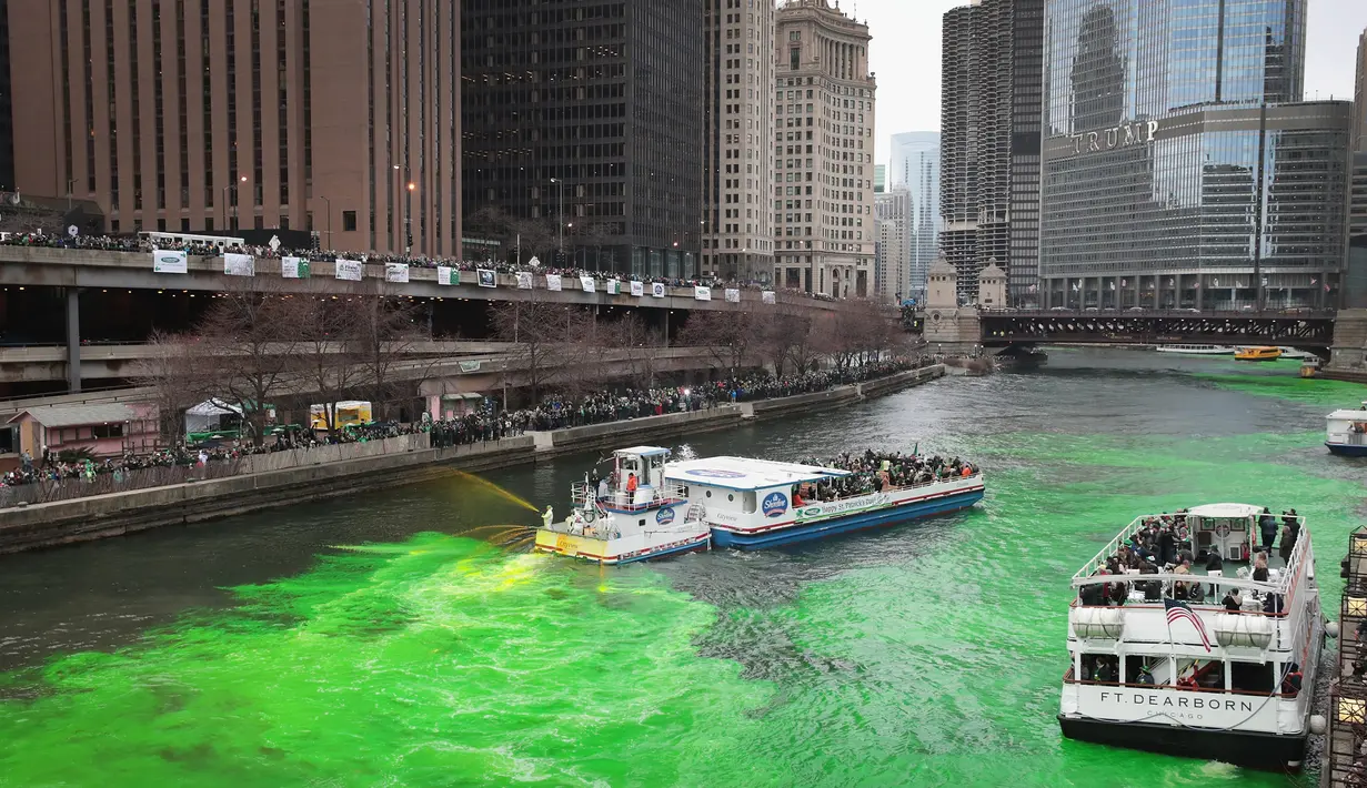 Petugas menggunakan kapal untuk menyemprotkan pewarna  hijau khusus ke sungai Chicago pada peringatan hari Santo Patrick di Illinois, Sabtu (17/3). Sungai itu setiap tahun mengalami perubahan warna demi memikat wisatawan. (Scott Olson/Getty Images/AFP)