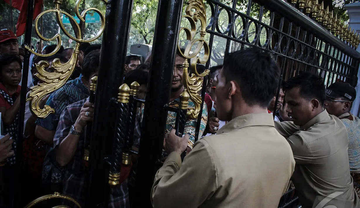 Petugas berjaga-jaga di depan gerbang Istana Negara untuk mengkondisikan massa yang berebut untuk masuk, Jakarta, Senin (20/10/2014) (Liputan6.com/Faizal Fanani)