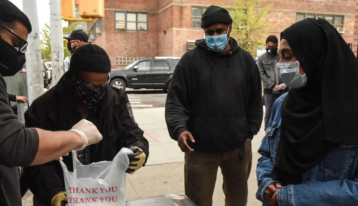 Orang-orang menerima makanan Halal gratis untuk Iftar selama bulan suci Ramadan di depan Masjid di masjid Taqwa di lingkungan Bedford-Stuyvesant di wilayah Brooklyn di New York (14/5/2020). (Stephanie Keith/Getty Images/AFP)