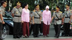 Jenderal Badrodin Haiti dan Jenderal Tito Karnavian, didampingi istri, tiba dalam upacara sertijab Kapolri di Stadion PTIK, Jakarta, Kamis (14/7). Badrodin resmi menyerahkan tongkat komando Kapolri kepada Tito. (Liputan6.com/Helmi Afandi)