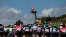 Penonton naik di atas crane saat menyambut pebalap yang berlomba di Etape1 Tour de France antara Mont-Saint-Michel dan Utah Beach Sainte-Marie-du-Mont, Normandy, (2/7/2016). (AFP/Kenzo Tribouillard)