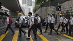 Para siswa sekolah mengenakan topeng dan helm berjalan di luar St. Paul's College selama protes di Hong Kong, Selasa (3/9/2019). Puluhan ribu siswa di Hong Kong mogok sekolah di hari pertama tahun ajaran baru. (AP Photo/Kin Cheung)