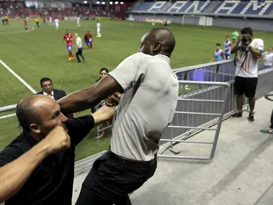 Pelatih tim nasional Kosta Rika, Paulo Wanchope (kanan) ketika terlibat baku hantam dengan petugas keamanan di tribun stadion Maracana, Panama, 11 Agustus 2015. Setelah kejadian itu, Wanchope memutuskan mundur dari jabatannya. (REUTERS)