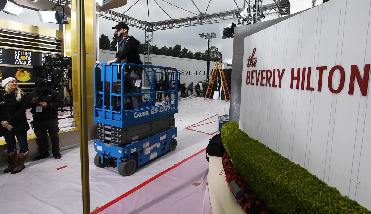 Pekerja dan staf menyiapkan area karpet merah ajang Golden Globe Awards 2019 di The Beverly Hilton, Beverly Hills, California, Sabtu (5/1). Golden Globe Awards 2019 adalah ajang ke-76  yang akan digelar pada 6 Januari waktu setempat. (Mark RALSTON/AFP)