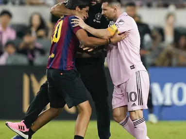 Bodyguard Lionel Messi, Yassine Chueko, kembali jadi sorotan. Dia dengan sigap meringkus fans yang menerobos lapangan demi bisa memeluk La Pulga saat Inter Miami bertandang ke markas Los Angeles FC dalam lanjutan Major League Soccer, Senin (4/9/2023). (AP Photo/Ryan Sun)