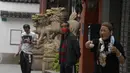 Warga beraktivitas di dekat singa batu di Yu Garden Mall di Shanghai (2/6/2022). Lalu lintas, pejalan kaki dan pelari muncul kembali di jalan-jalan Shanghai ketika kota terbesar di China mulai kembali normal di tengah pelonggaran penguncian COVID-19 dua bulan yang ketat atas penerapannya. (AP Photo/Ng Han Guan)