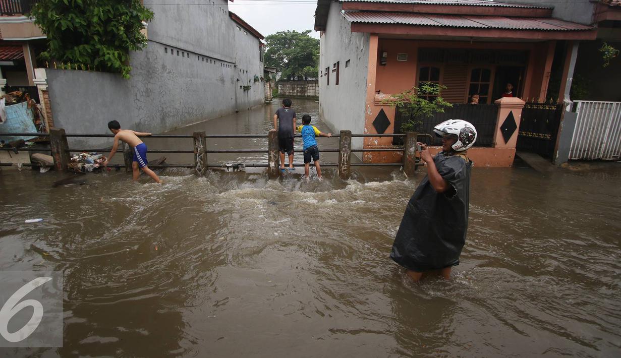 Warga melintasi banjir yang menggenangi Jalan Ketapang di kawasan Pasar Minggu, Jakarta, Selasa (4/10). Banjir yang berasal dari luapan Kali Anur tersebut menyebabkan Jalan Ketapang tidak bisa dilewati kendaraan. (Liputan6.com/Immanuel Antonius)