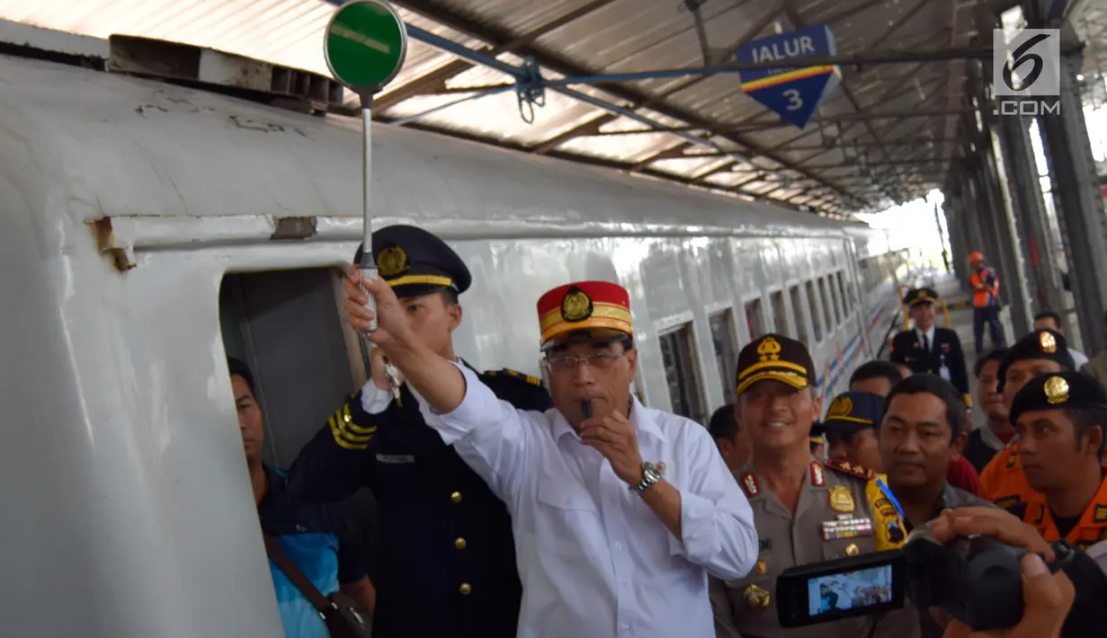 Menteri Perhubungan (Menhub) Budi Karya Sumadi meniup peluit keberangkatan KA Tawang Jaya di Stasiun Semarang Poncol, Jawa Tengah, Kamis (29/6). Menhub melakukan pengecekan kesiapan arus balik Lebaran 2017 di stasiun tersebut (Liputan6.com/Gholib)